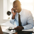 iboutchou img Smiling,Young,African,Businessman,Talking,To,A,Client,On,His